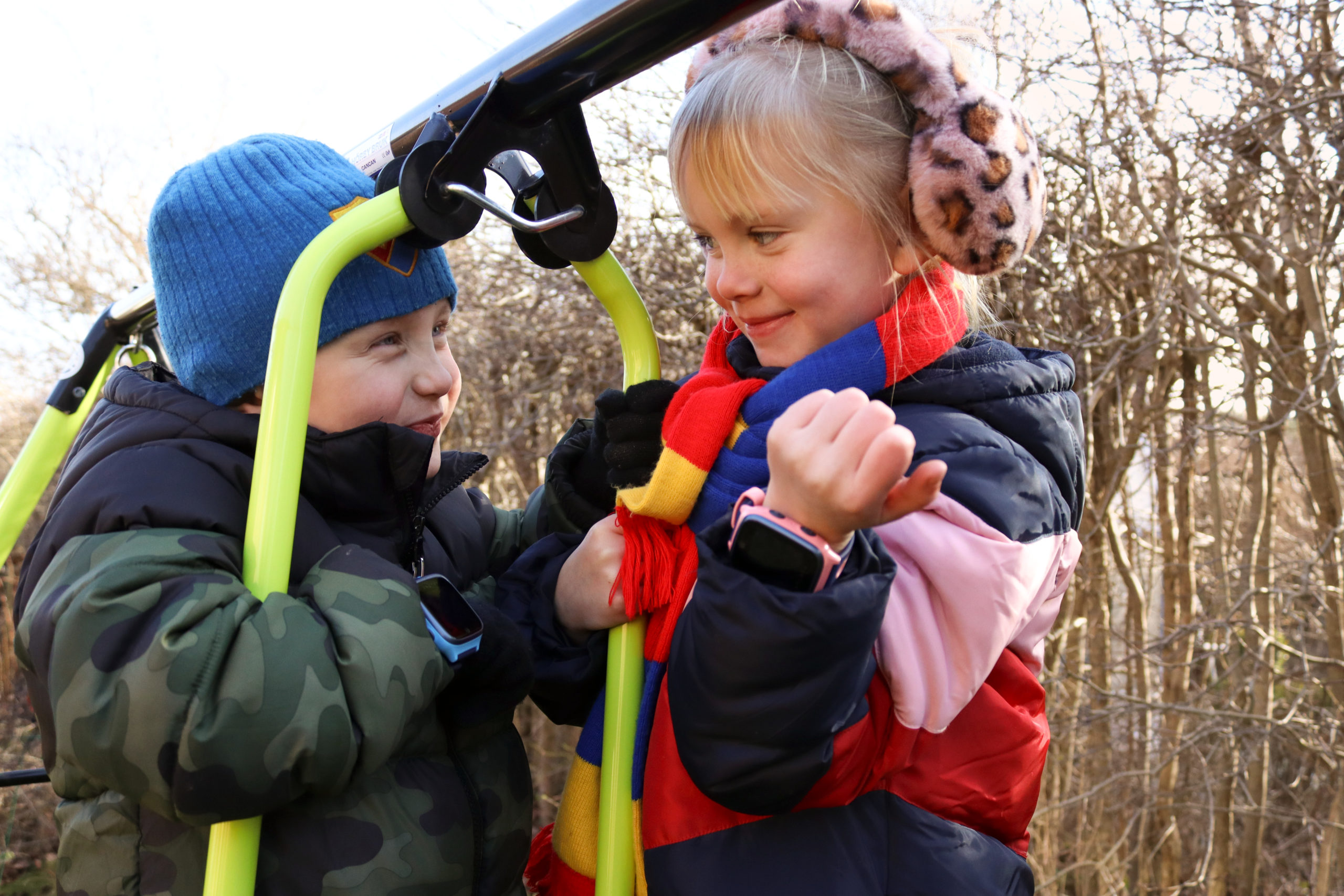 To aktive barn som leker ute med hver sin xplora klokke.